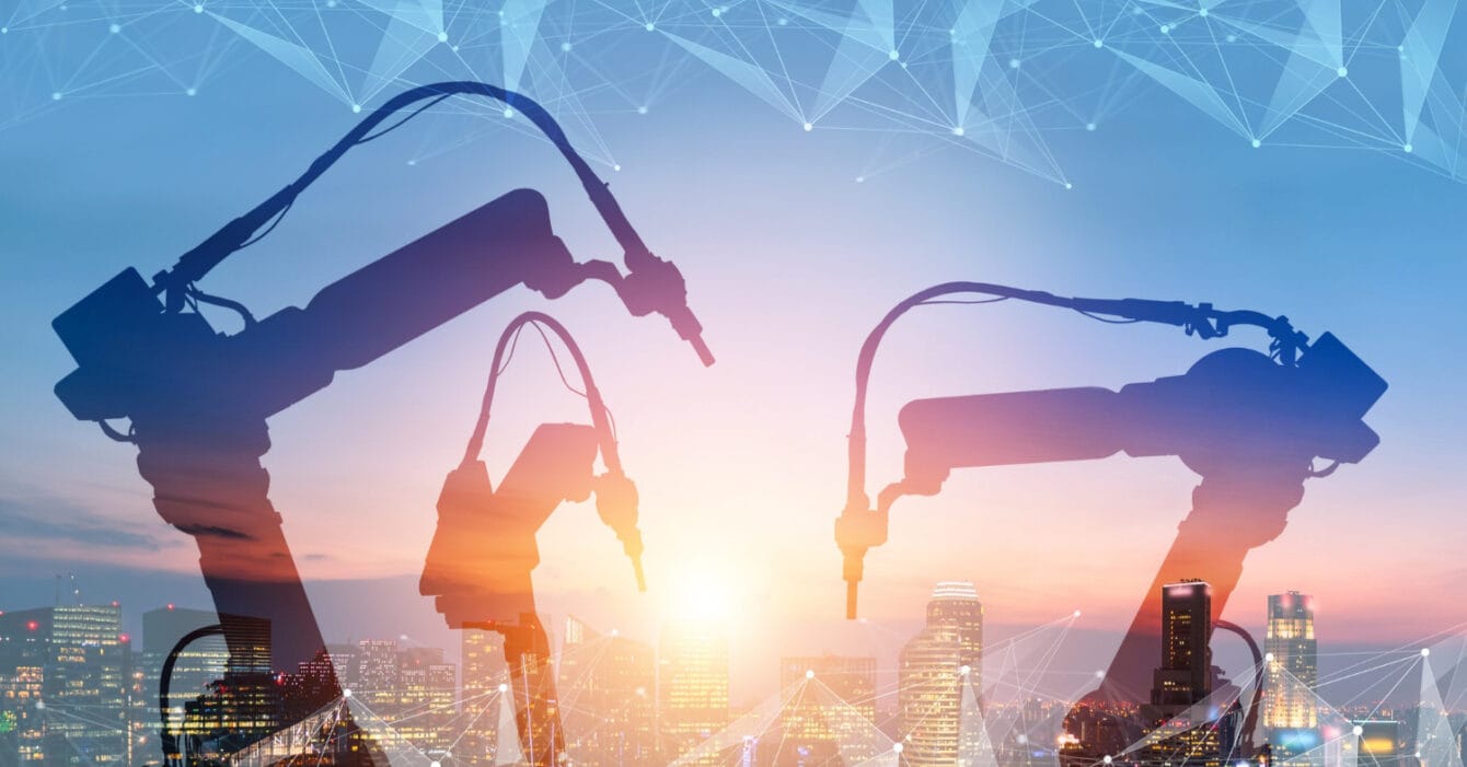 Industrial robotic arms silhouette against a cityscape at sunset with digital network connections, symbolising Automated Construction Methods Southeast Asia.