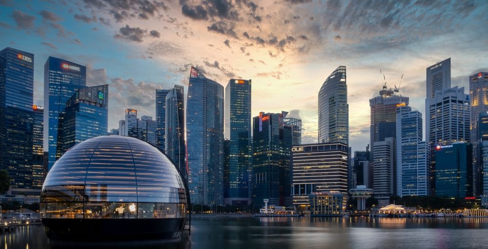 Dusk view of a Singapore's skyline with modern buildings and a glass dome on the waterfront, showing the Southeast Asia Real Estate Trends.