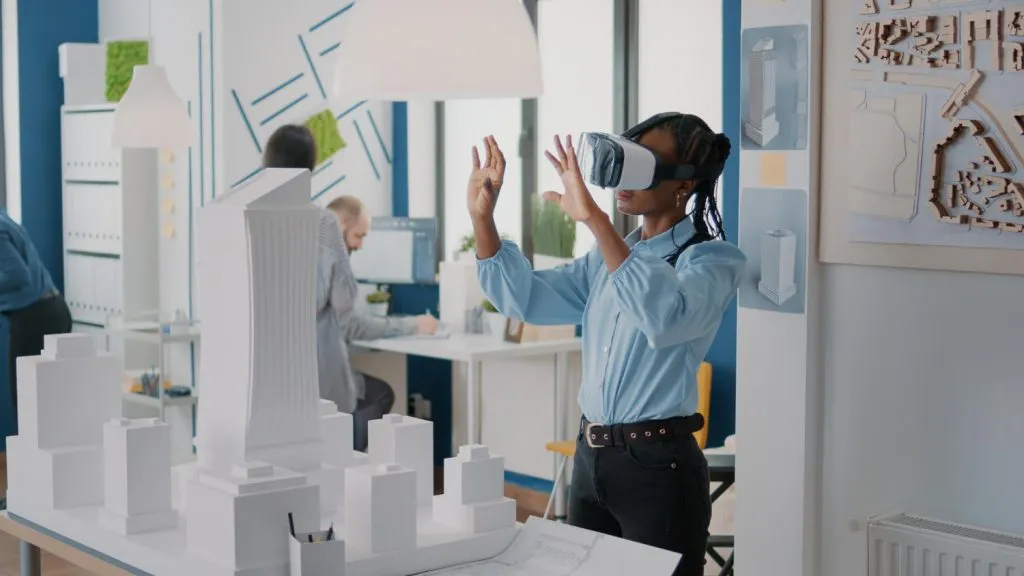 Digital Construction Tools in Southeast Asia: Person using VR headset with architectural models on a table in an office setting.